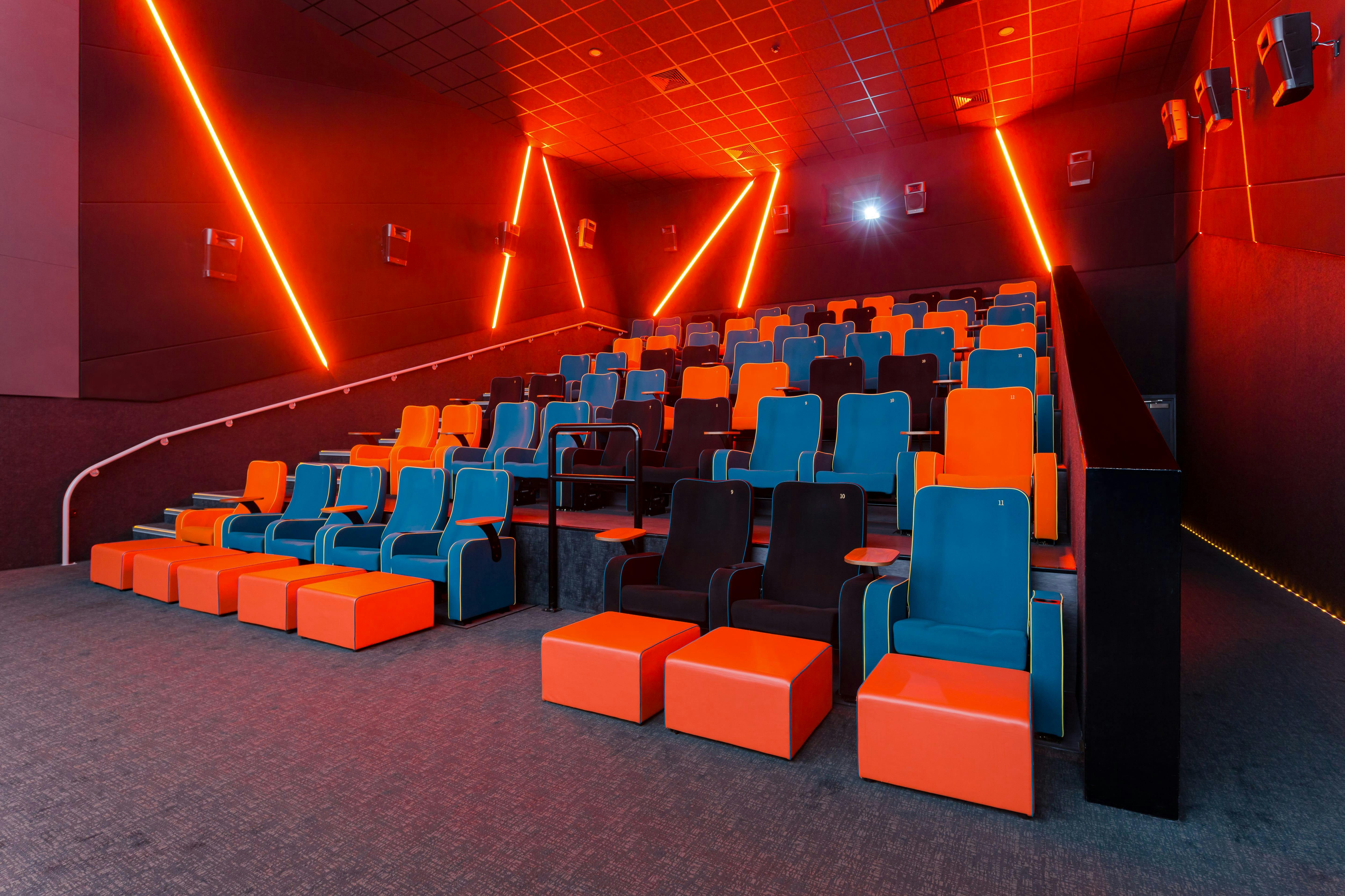 Modern auditorium with tiered seating in vibrant blue and orange at The Light Cinema Stockport.