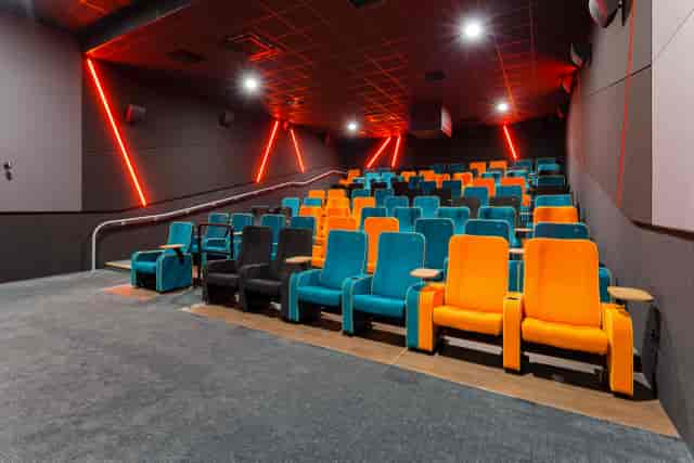 Modern cinema auditorium with tiered orange and teal seating for film screenings and events.