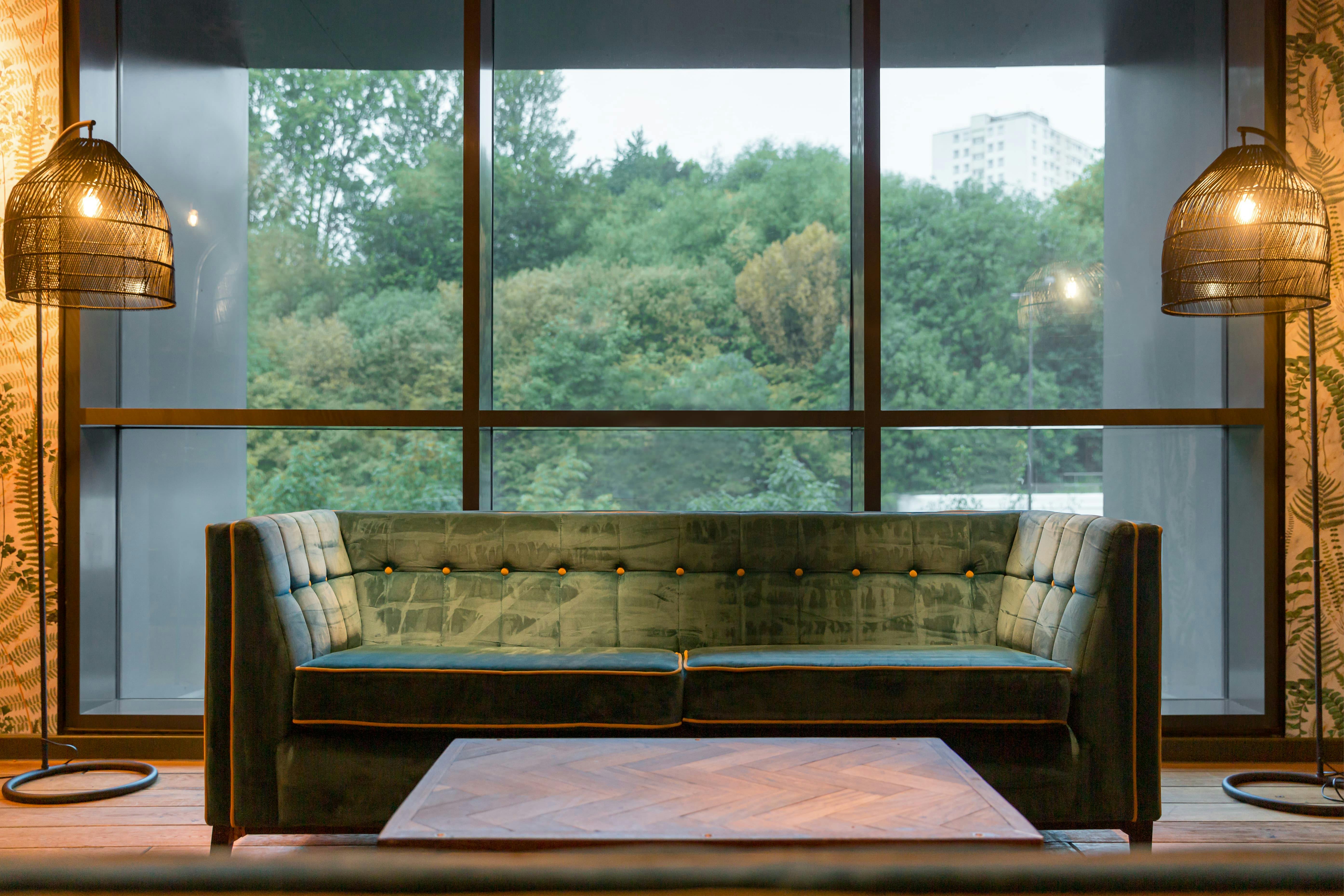 Stylish lounge at Babylon Bar, featuring plush green sofa for networking events.