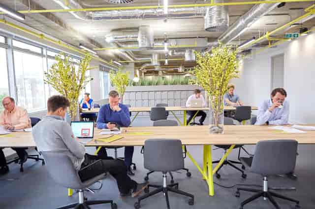 Modern open-concept workspace with communal tables for meetings and brainstorming events.