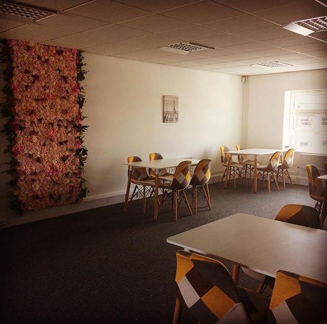 Bright minimalist meeting space with floral accent wall for workshops and events.