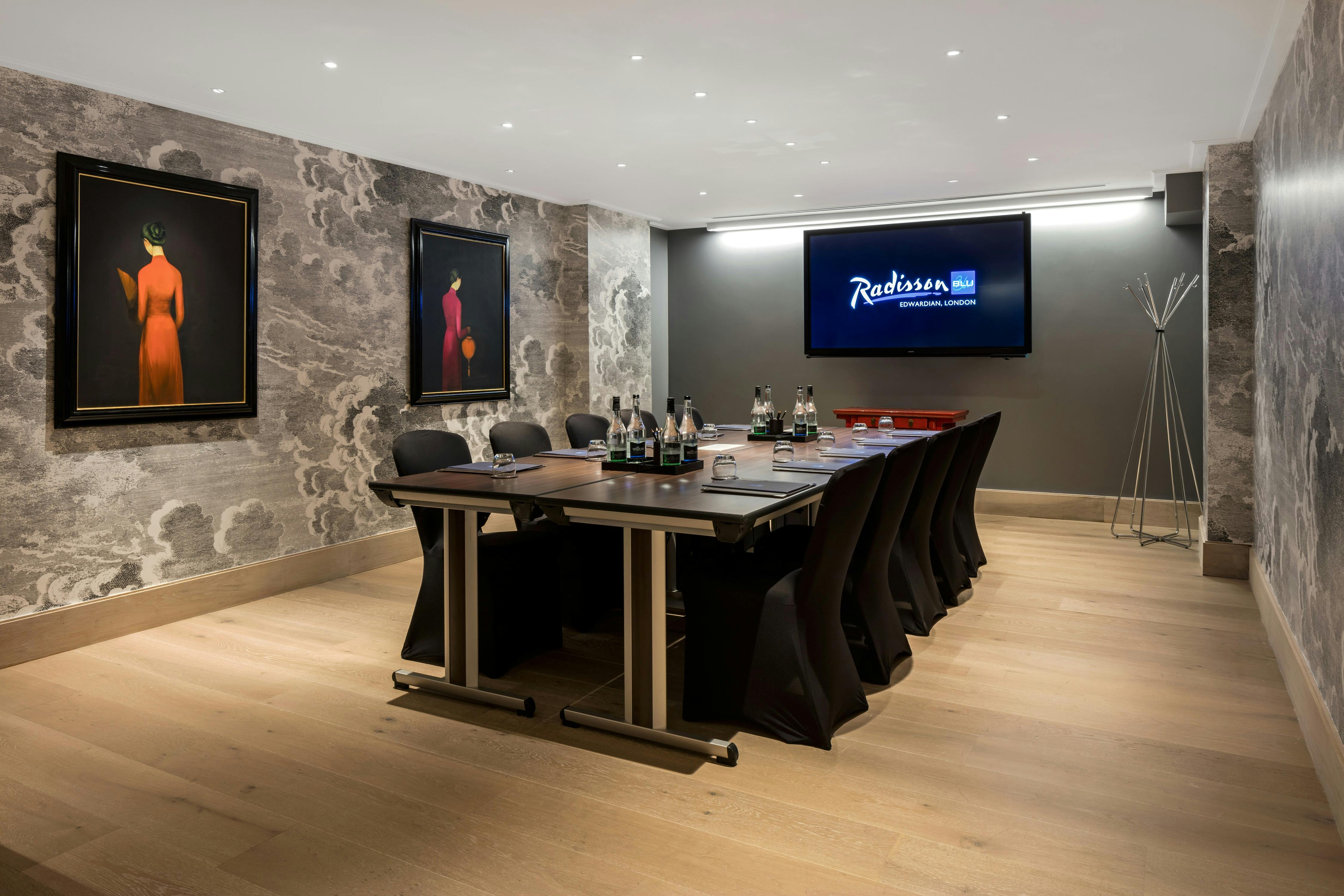 Modern meeting room in Radisson Blu London with sleek table and advanced presentation screen.