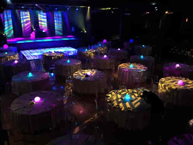 Elegant event space at Commodore Ballroom with round tables and vibrant stage lighting.