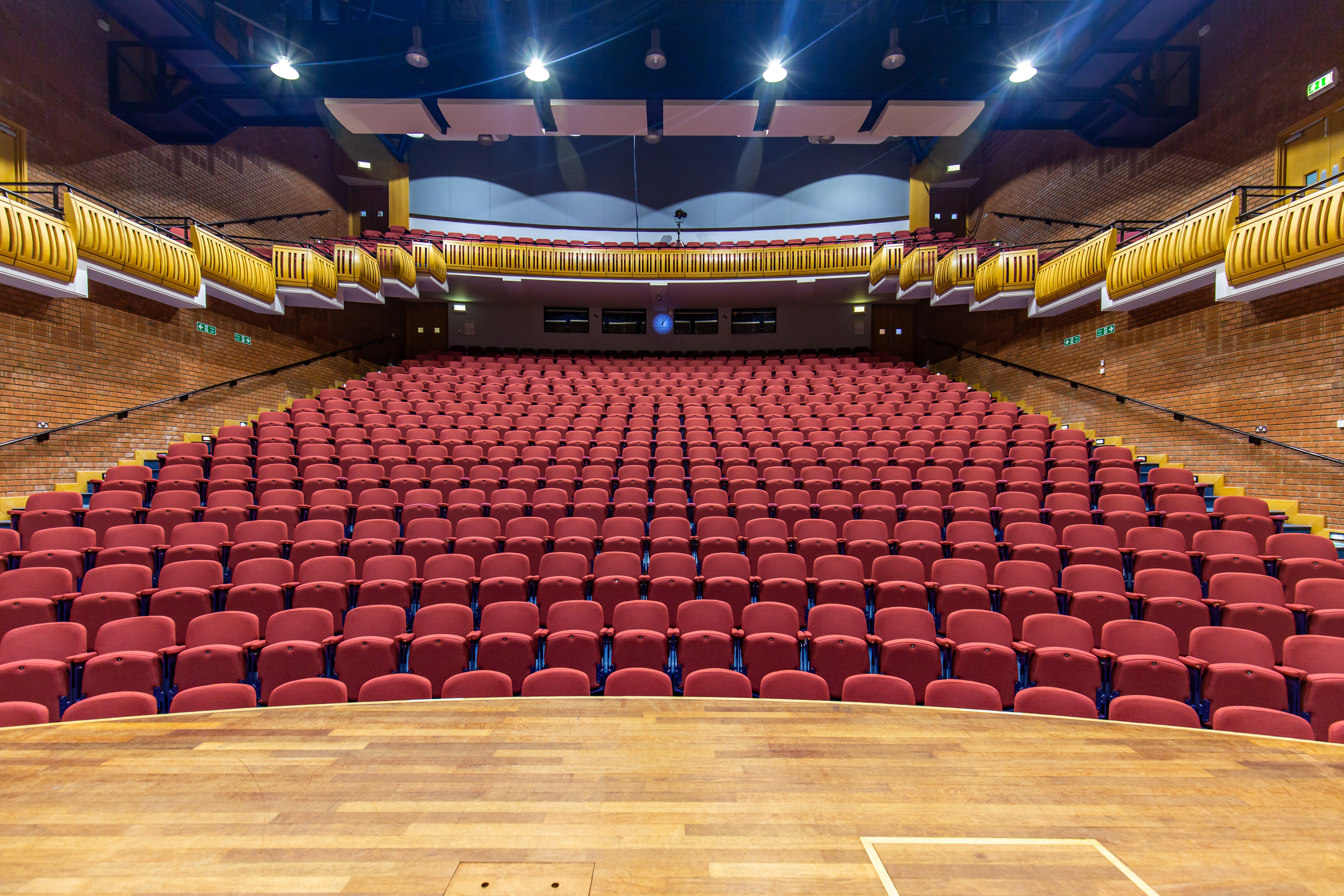 Spacious auditorium with tiered red seating for conferences and presentations in Marden Park. - Banner