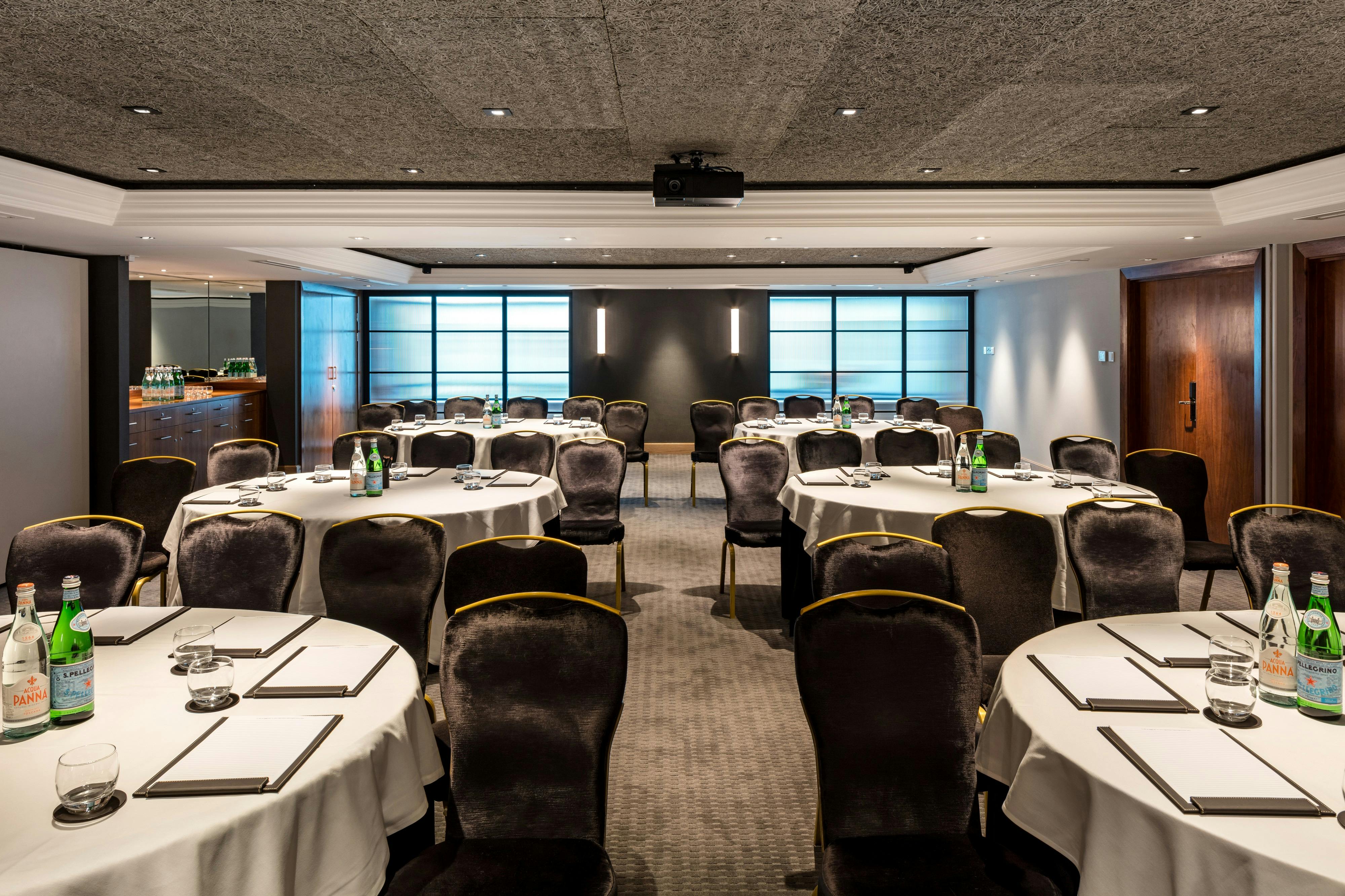 Elegant meeting room with round tables for corporate events at The Edwardian Manchester.