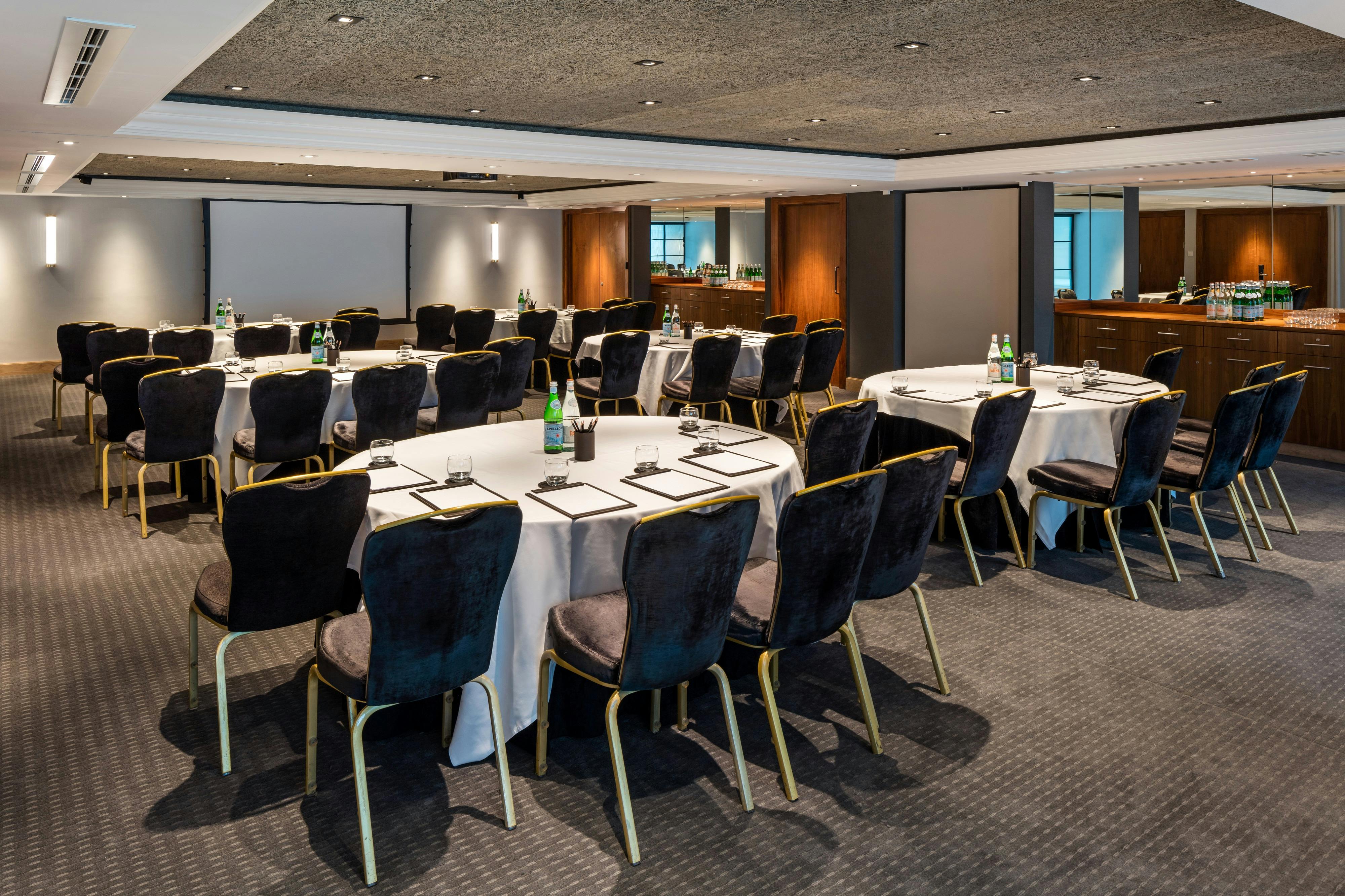 Elegant meeting room with circular tables, ideal for corporate events and workshops.