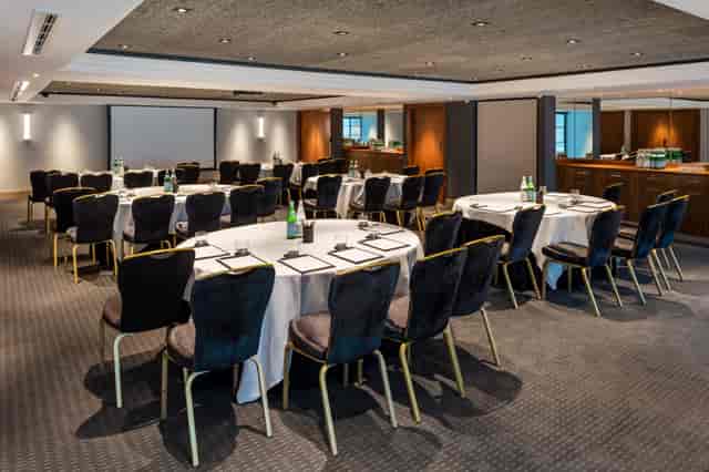 Elegant meeting room with circular tables, ideal for professional events and workshops.