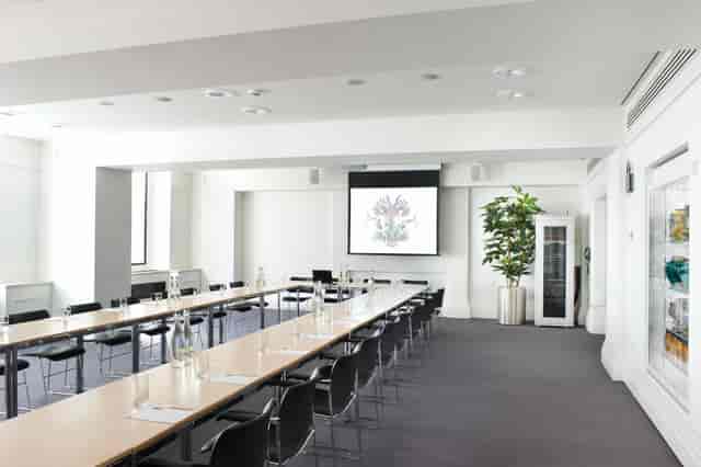 Modern meeting room with long table and ergonomic chairs for corporate workshops.