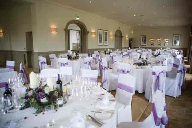 Elegant wedding venue with round tables, white linens, and floral centerpieces.