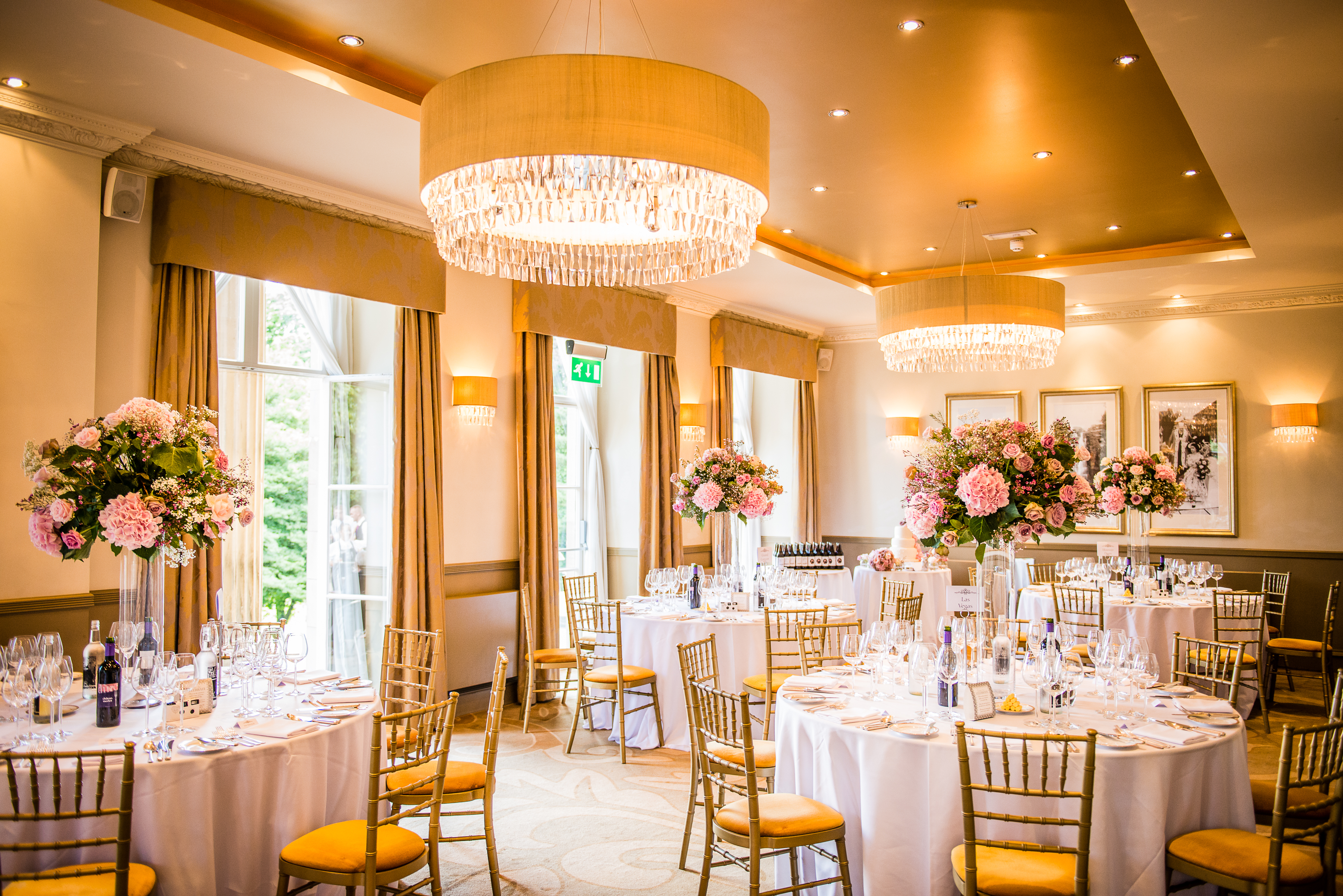 Elegant event space in The Mansion with round tables, ideal for weddings and corporate events. - Banner