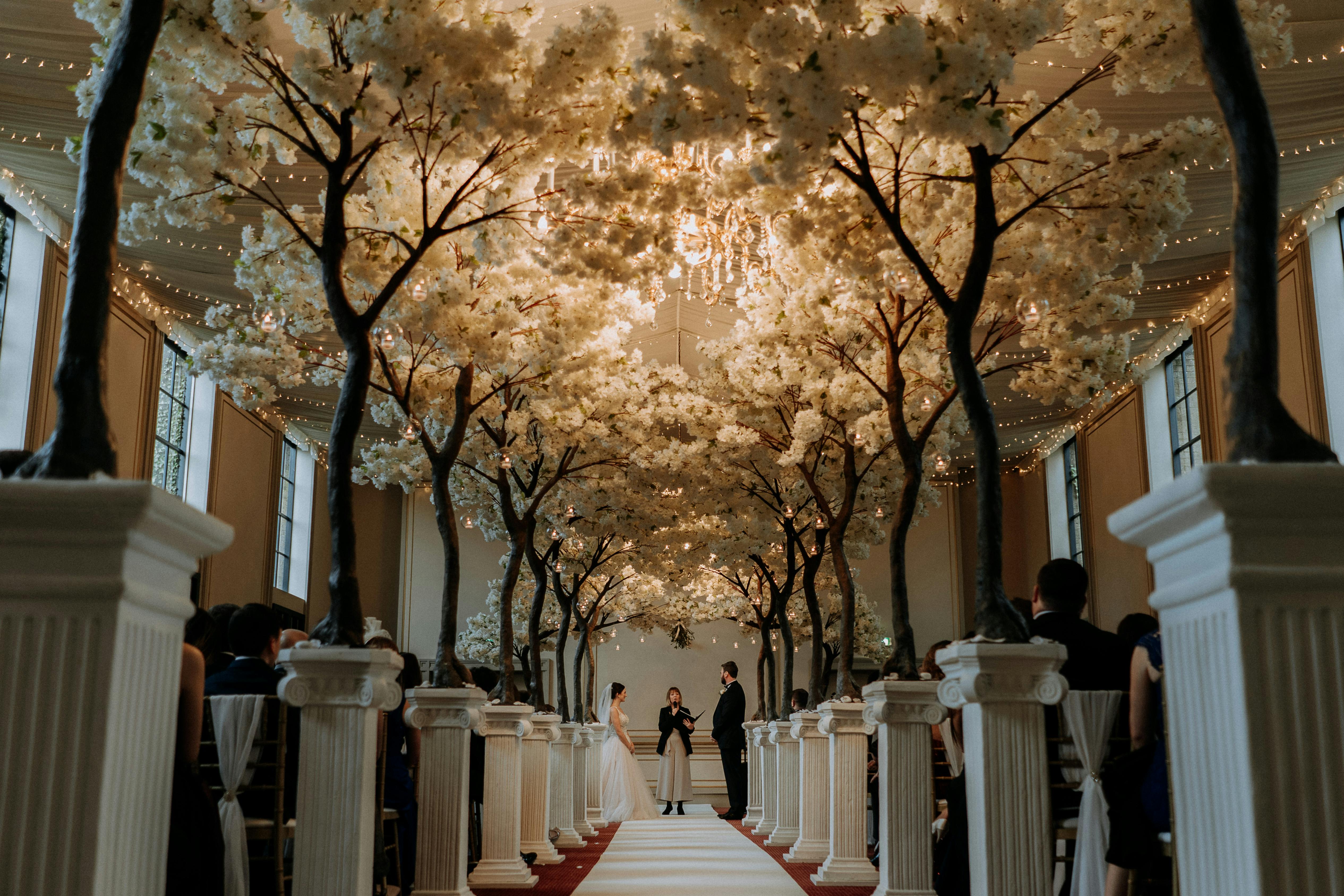 Elegant wedding ceremony space at Rise Hall with floral arrangements and white pillars.