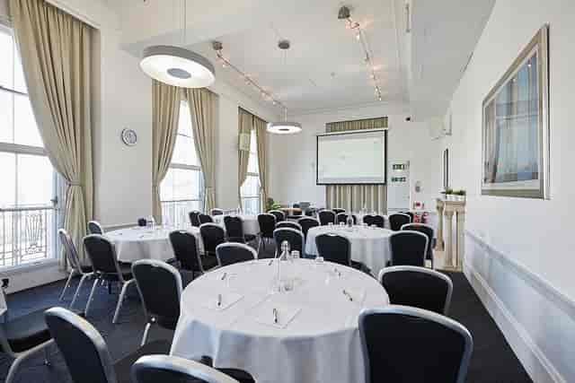 Corporate meeting room with round tables, ideal for workshops and presentations.