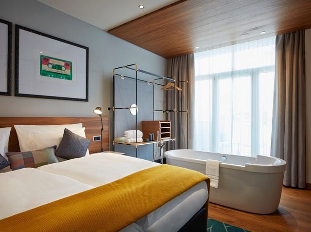 Modern hotel room with cozy bed and freestanding bathtub in Hard Rock Hotel Davos.