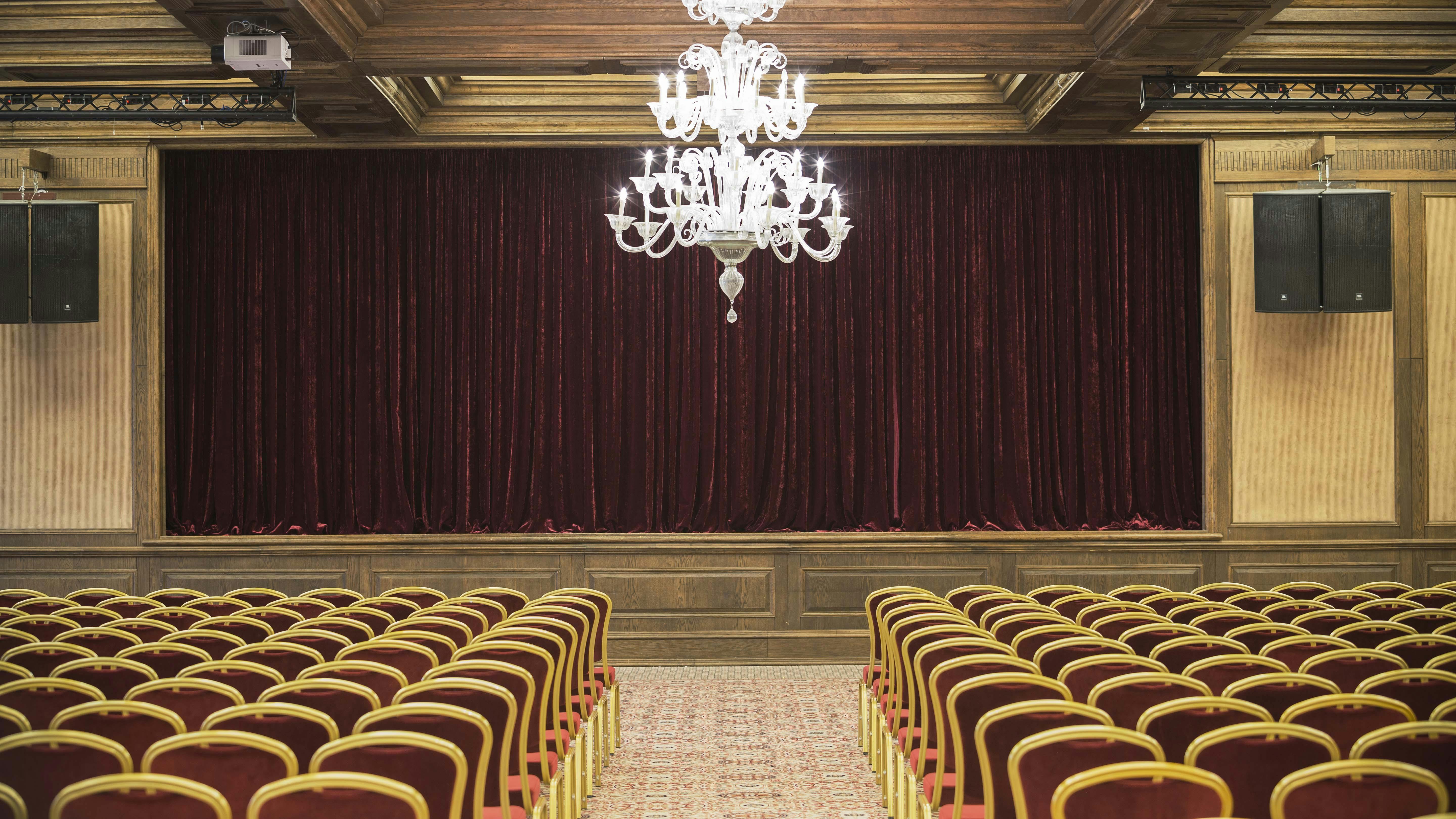 Grand Opera event space with burgundy curtains, ideal for corporate events and performances.