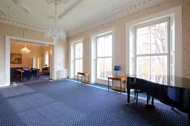 Elegant event space at Clifton Hill House with large windows and grand piano for receptions.