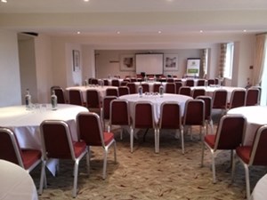 Cambridge Suite meeting room with round tables, ideal for events and presentations. - Banner