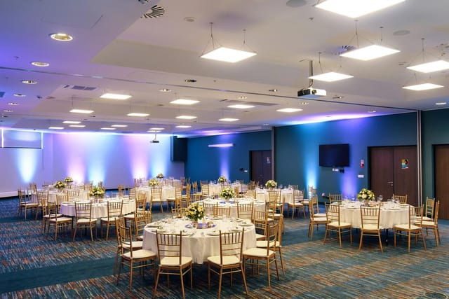 Elegant ballroom with round tables, perfect for banquets and corporate events.