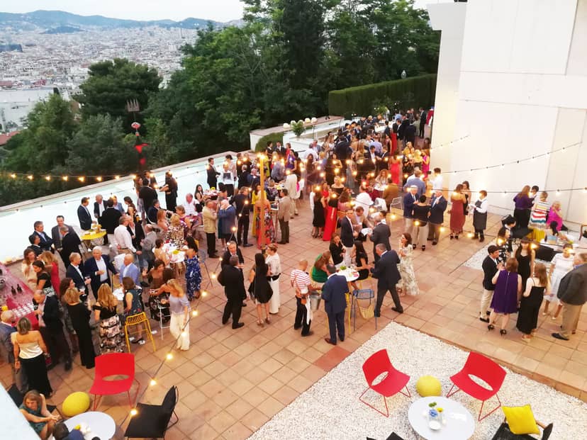 Vibrant cocktail reception at Fundació Joan Miró's North Patio with city backdrop.