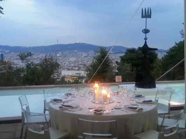 Elegant outdoor dining setup with city view at Fundació Joan Miró for upscale events.