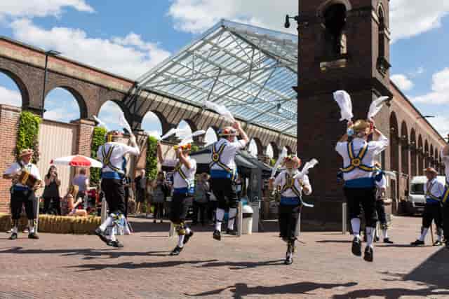 Lively outdoor event at The Carriage Shed with traditional dancers and greenery.
