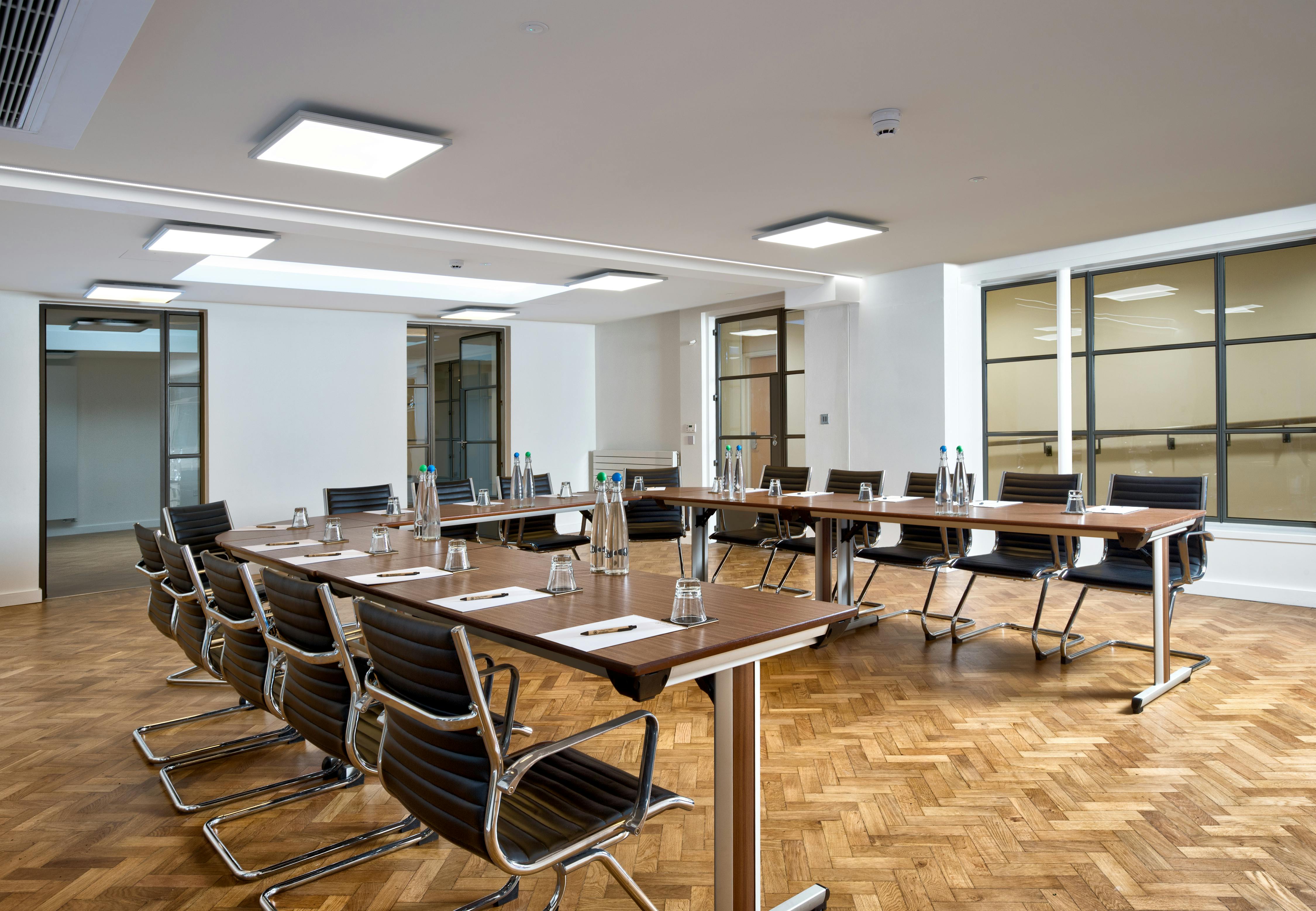 Modern meeting room with large table, ideal for workshops and strategic meetings.