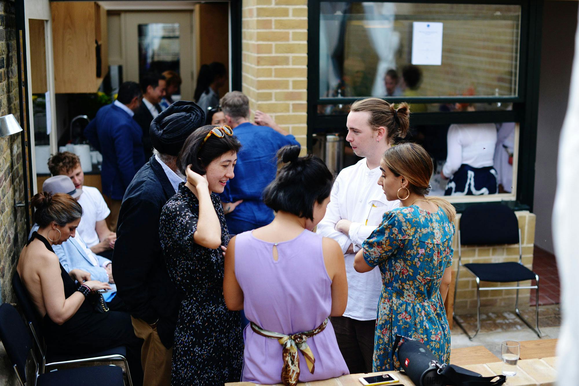 Vibrant networking event in Van Gogh House's garden with engaged attendees.