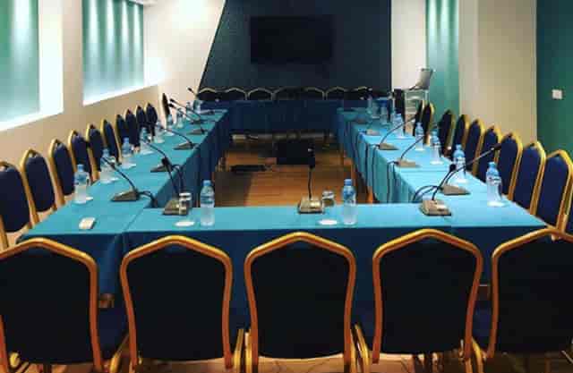 Conference room setup at VH Premier as Tirana Hotel with modern decor and microphones.
