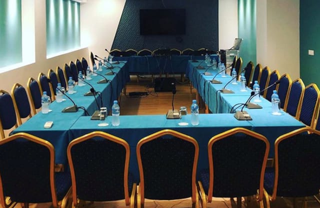 Conference room setup at VH Premier as Tirana Hotel with modern decor and microphones.