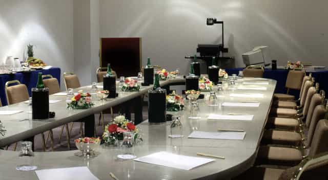 Elegant meeting room setup with floral centerpieces for professional conference.