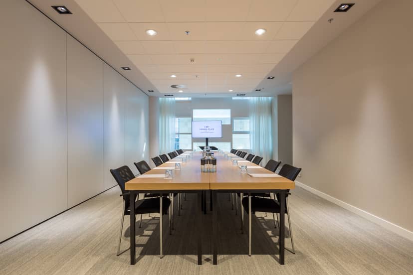 Modern meeting room at Crowne Plaza Utrecht with long wooden table for collaboration.