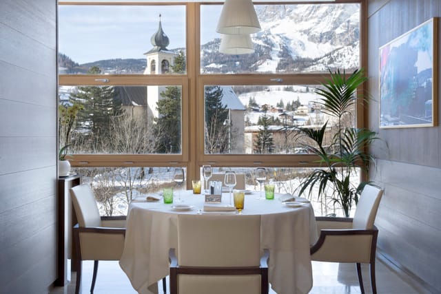 Elegant dining table with mountain view at GRAND HOTEL SAVOIA for exclusive events.