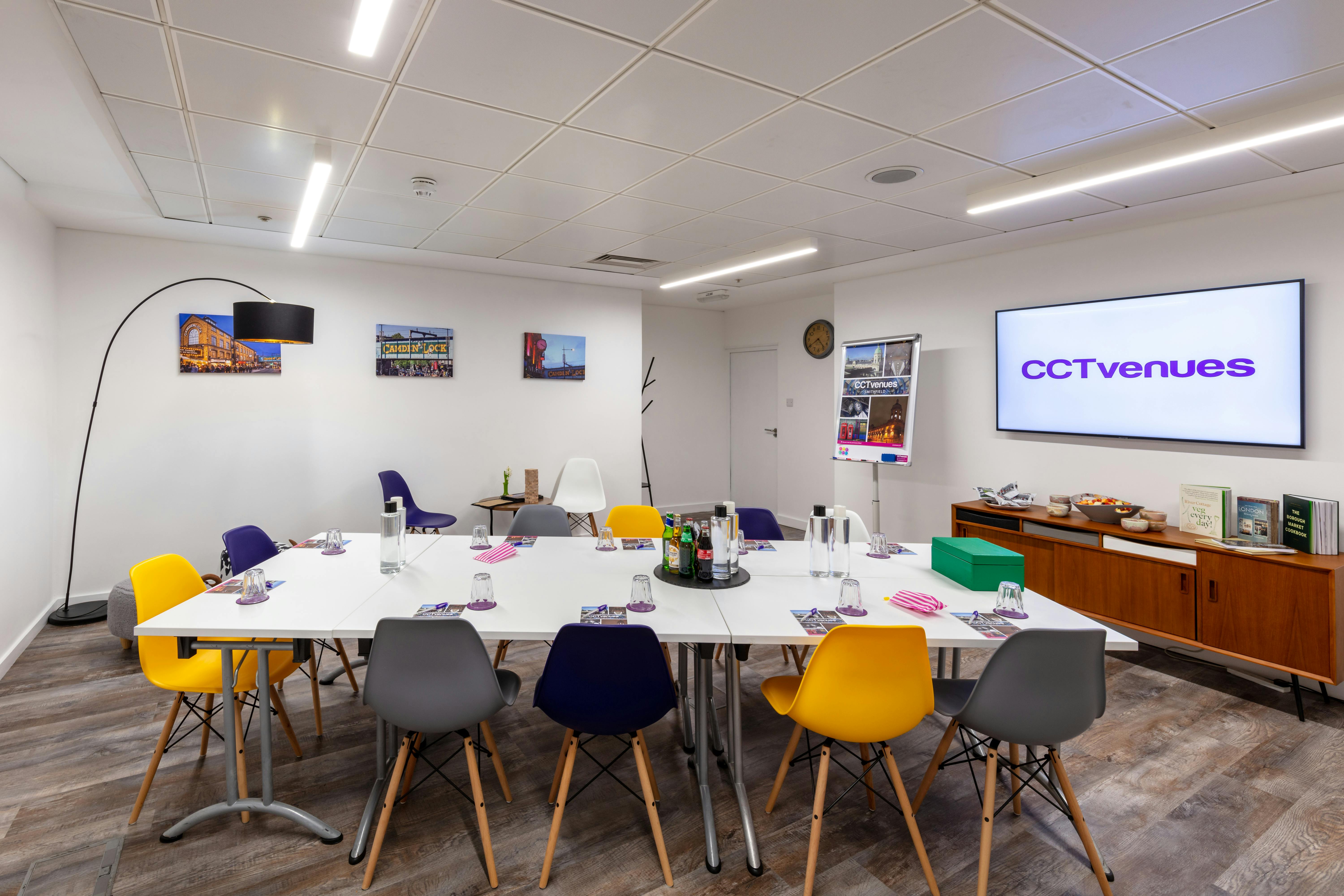 Modern meeting room at Camden Lock, featuring a large table and colorful chairs for collaboration.