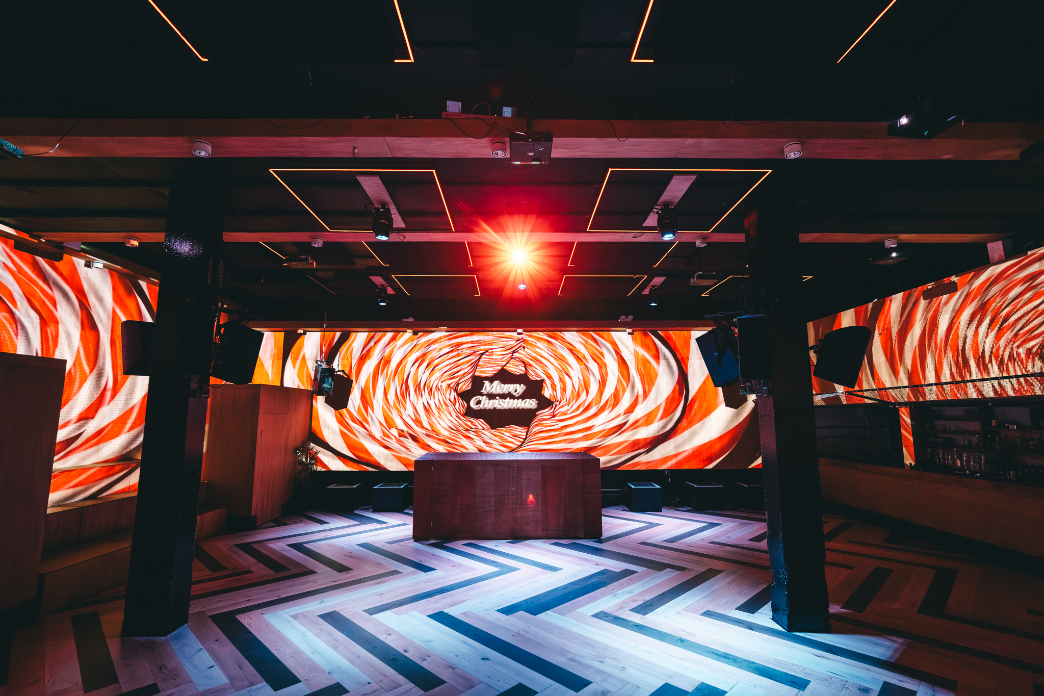 Modern event venue with colorful projections, perfect for Christmas parties and corporate events. - Banner