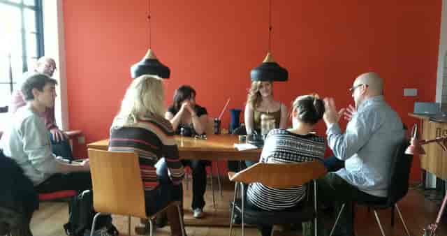 Collaborative meeting at HOURS with round table in vibrant, inviting atmosphere.