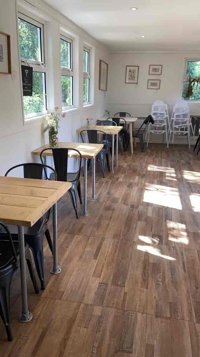 Versatile event space with wooden tables and metal chairs for casual meetings or gatherings.