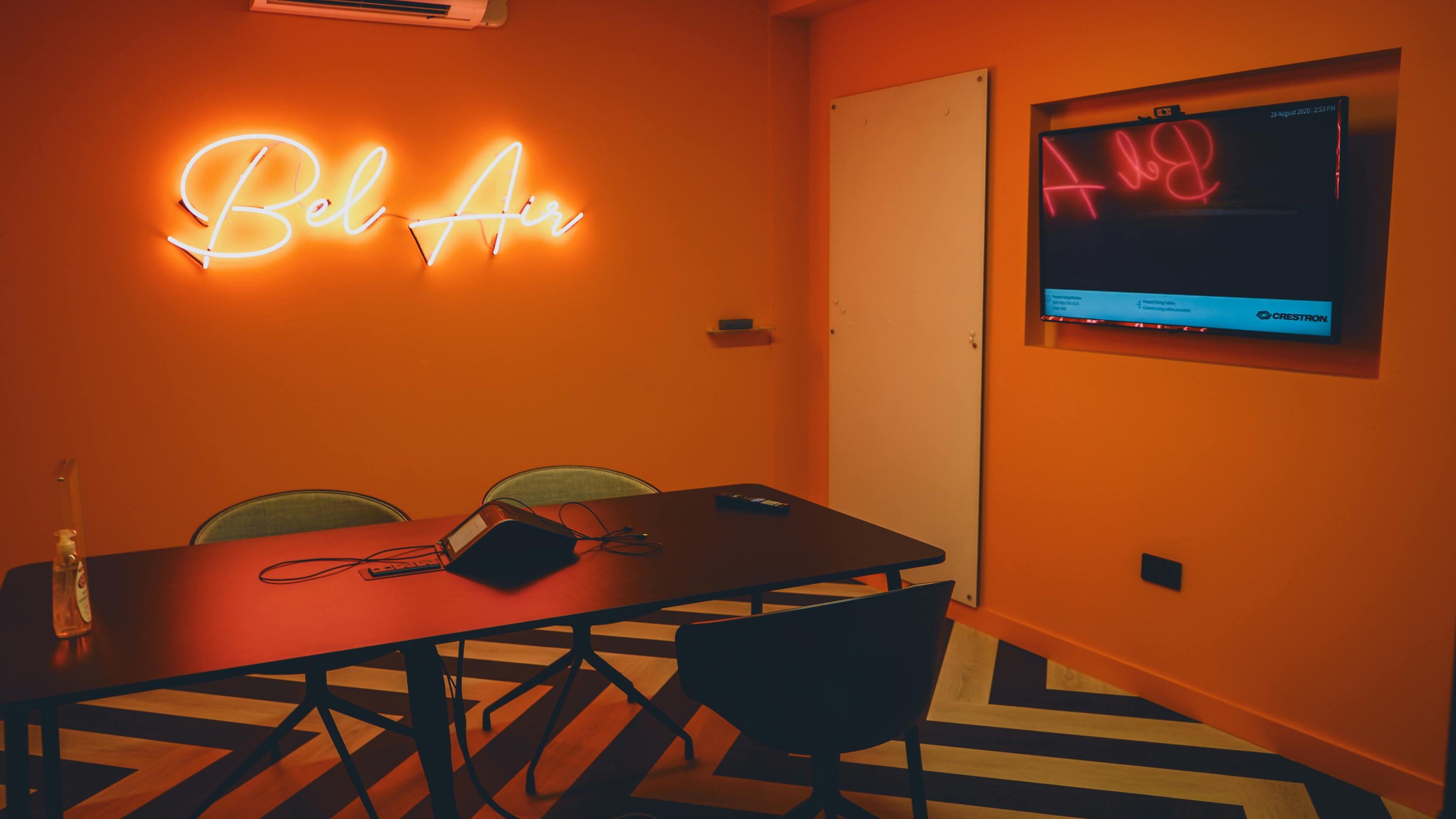 Vibrant Bel Air meeting room with orange walls, ideal for creative brainstorming sessions.