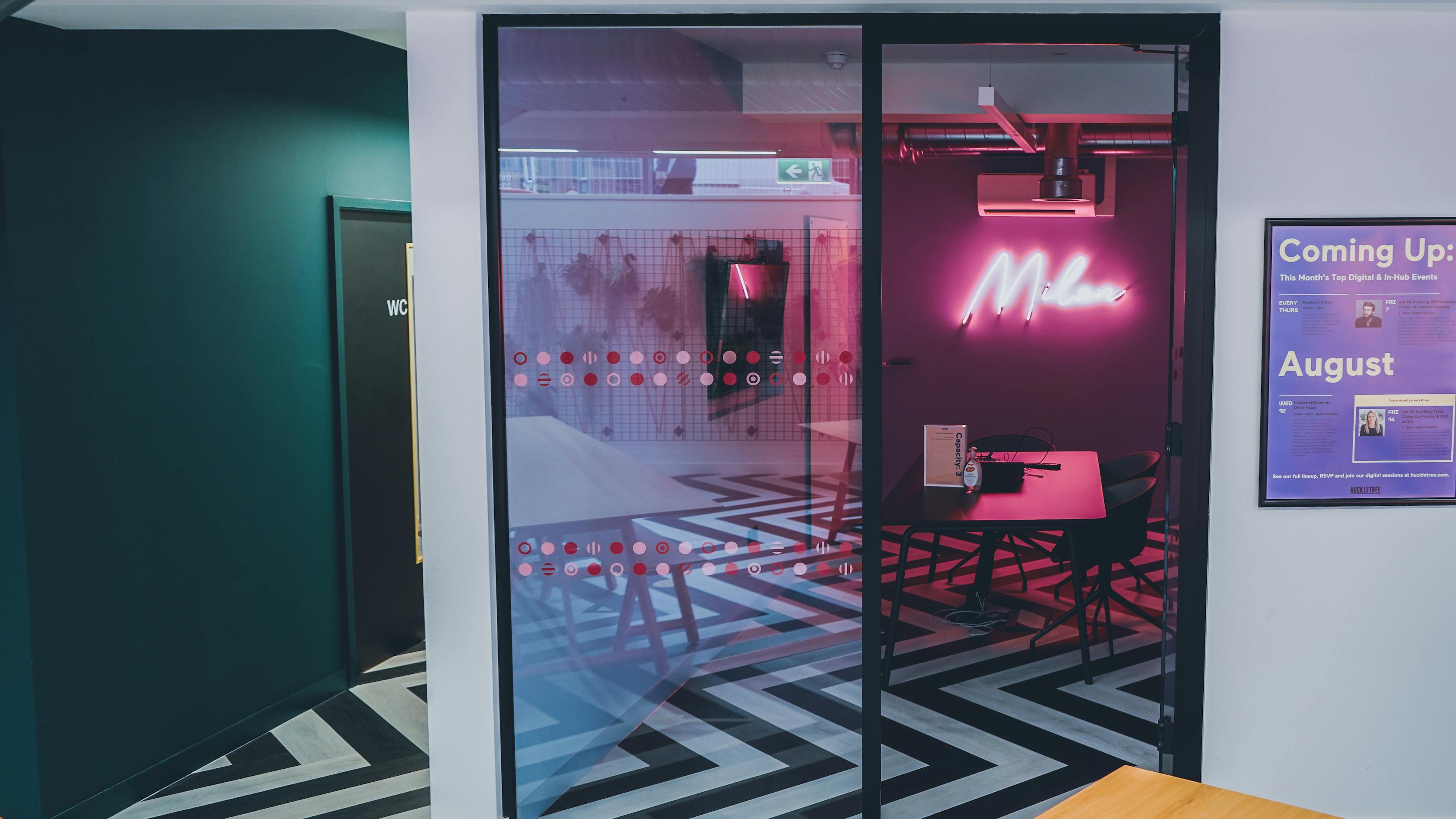 Modern meeting space in Milan with neon sign, ideal for workshops and brainstorming.