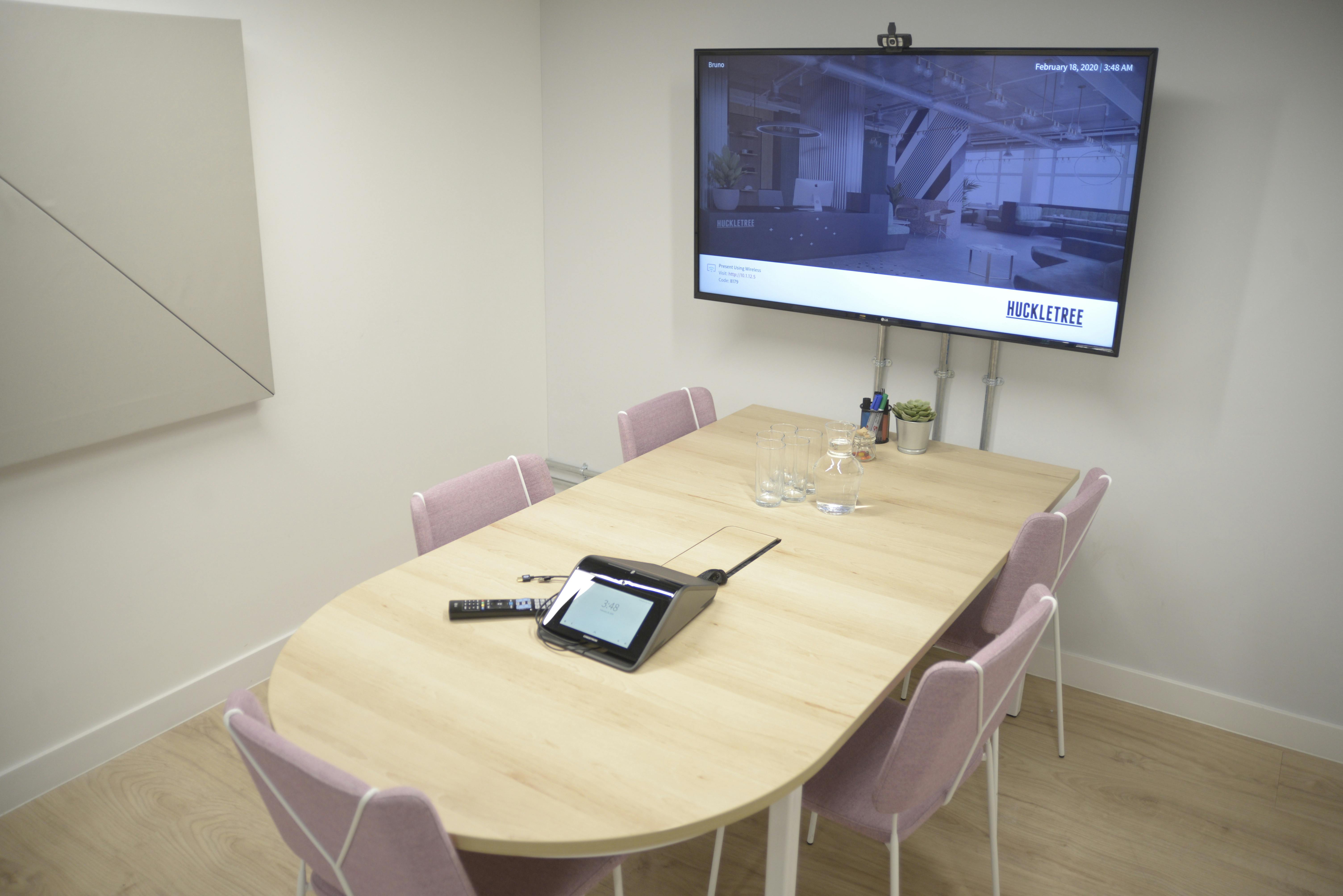 Bruno Meeting Room at Huckletree Soho with oval table and pink chairs for collaboration.