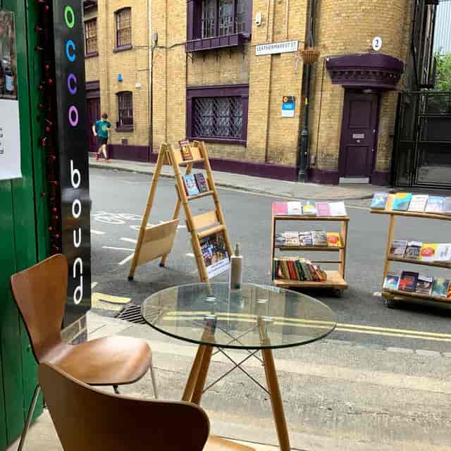 Charming outdoor meeting space at Morocco Bound Bookshop with glass table and books.