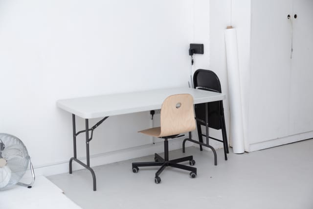 Minimalist Cove Studio setup with folding table and chairs for events and meetings.