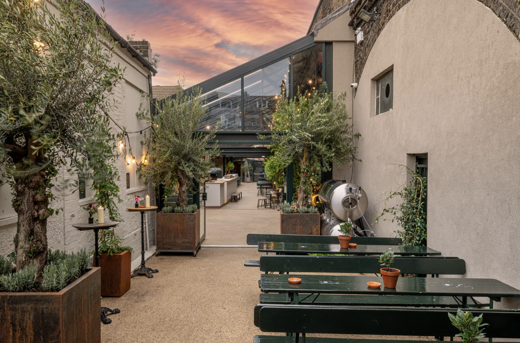 Stylish outdoor venue with greenery, ideal for receptions and casual meetings. - Banner