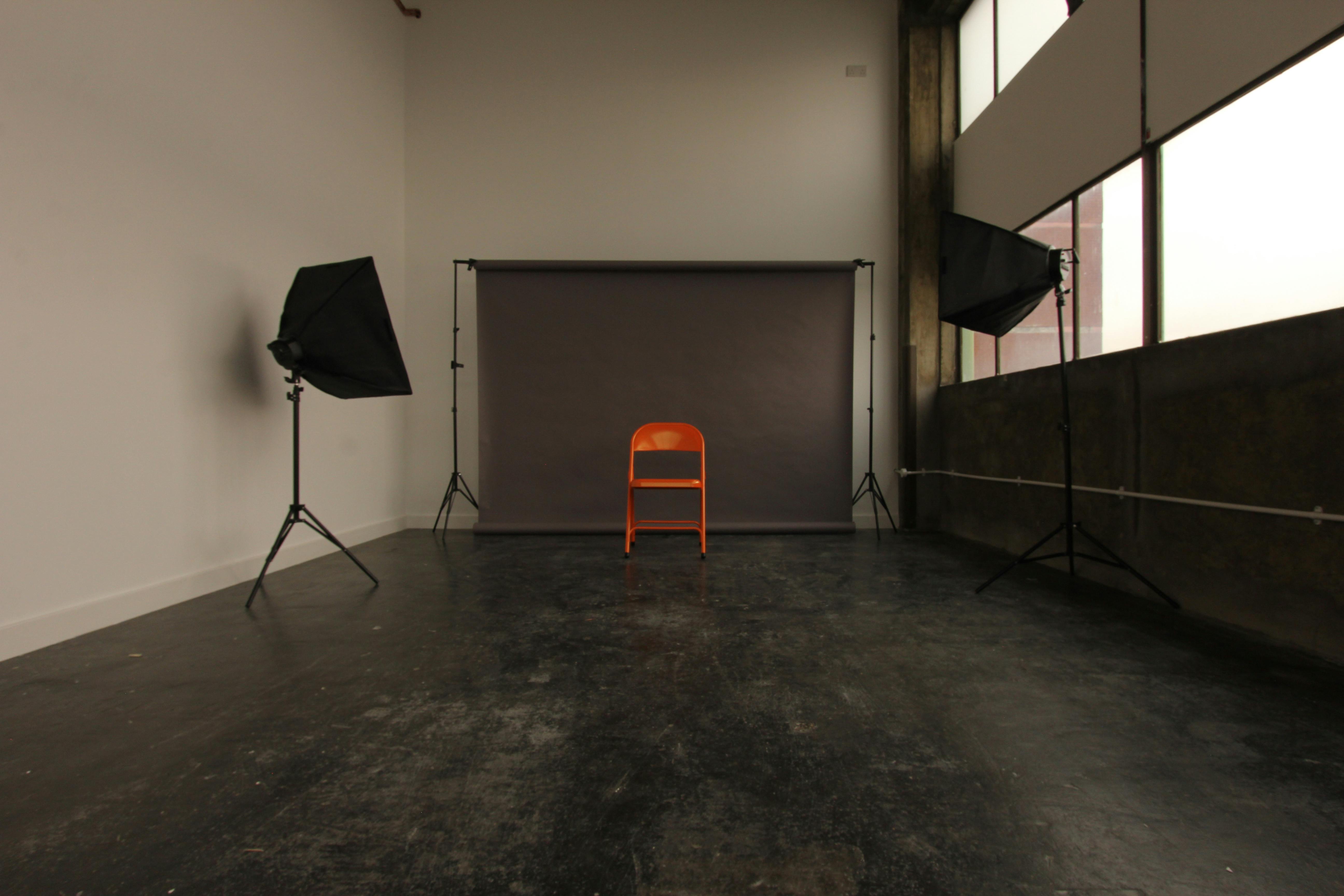 Minimalist meeting venue with orange chair, ideal for interviews and workshops.