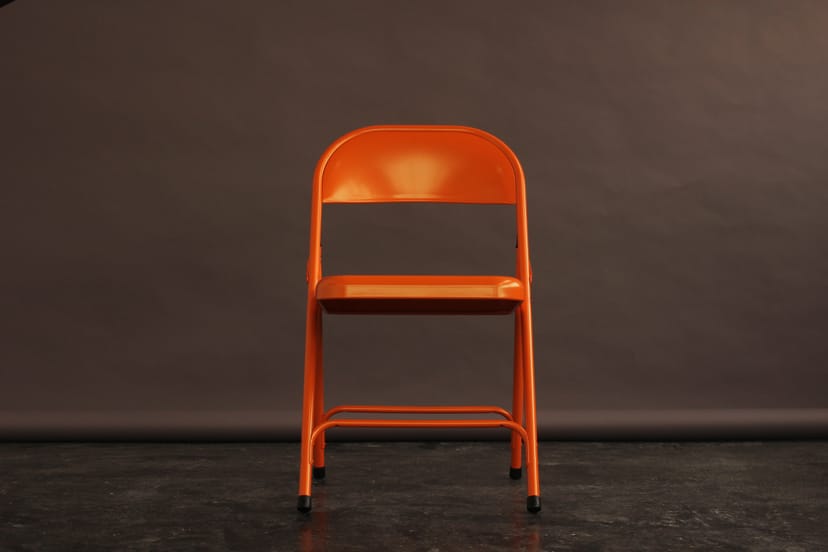 Vibrant orange chair in Aseptic Studios for modern meetings and creative workshops.