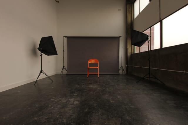Minimalist meeting venue with orange chair, ideal for interviews and events.