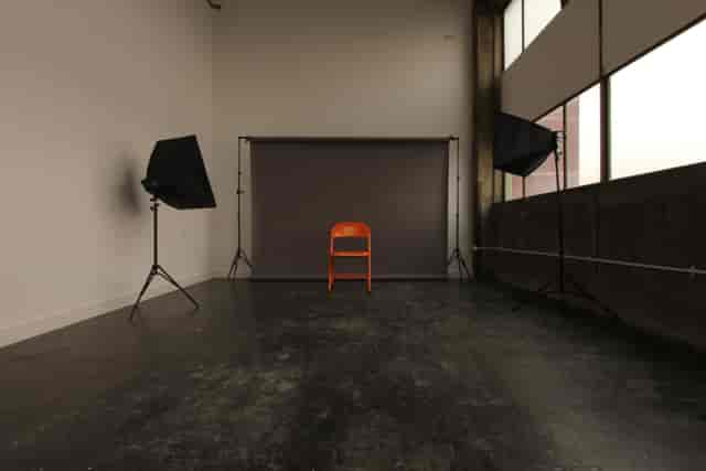 Minimalist meeting venue with orange chair, ideal for presentations and interviews.