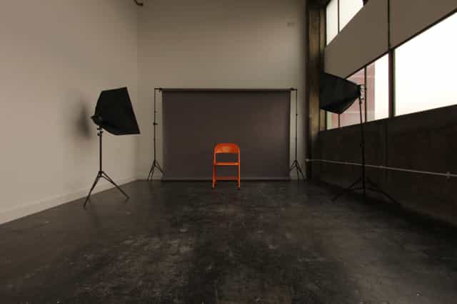 Minimalist meeting venue with orange chair, ideal for presentations and interviews.