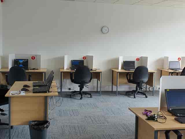 Minimalist conference room with computers for hybrid meetings and small group events.