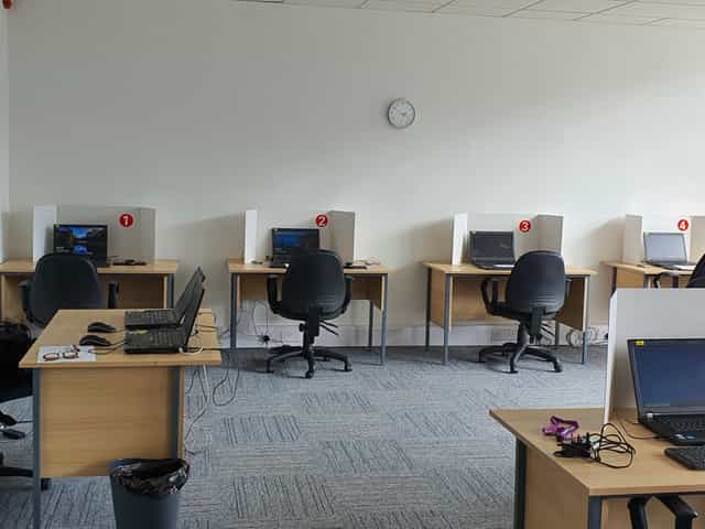Minimalist conference room with computers for hybrid meetings and small group events.