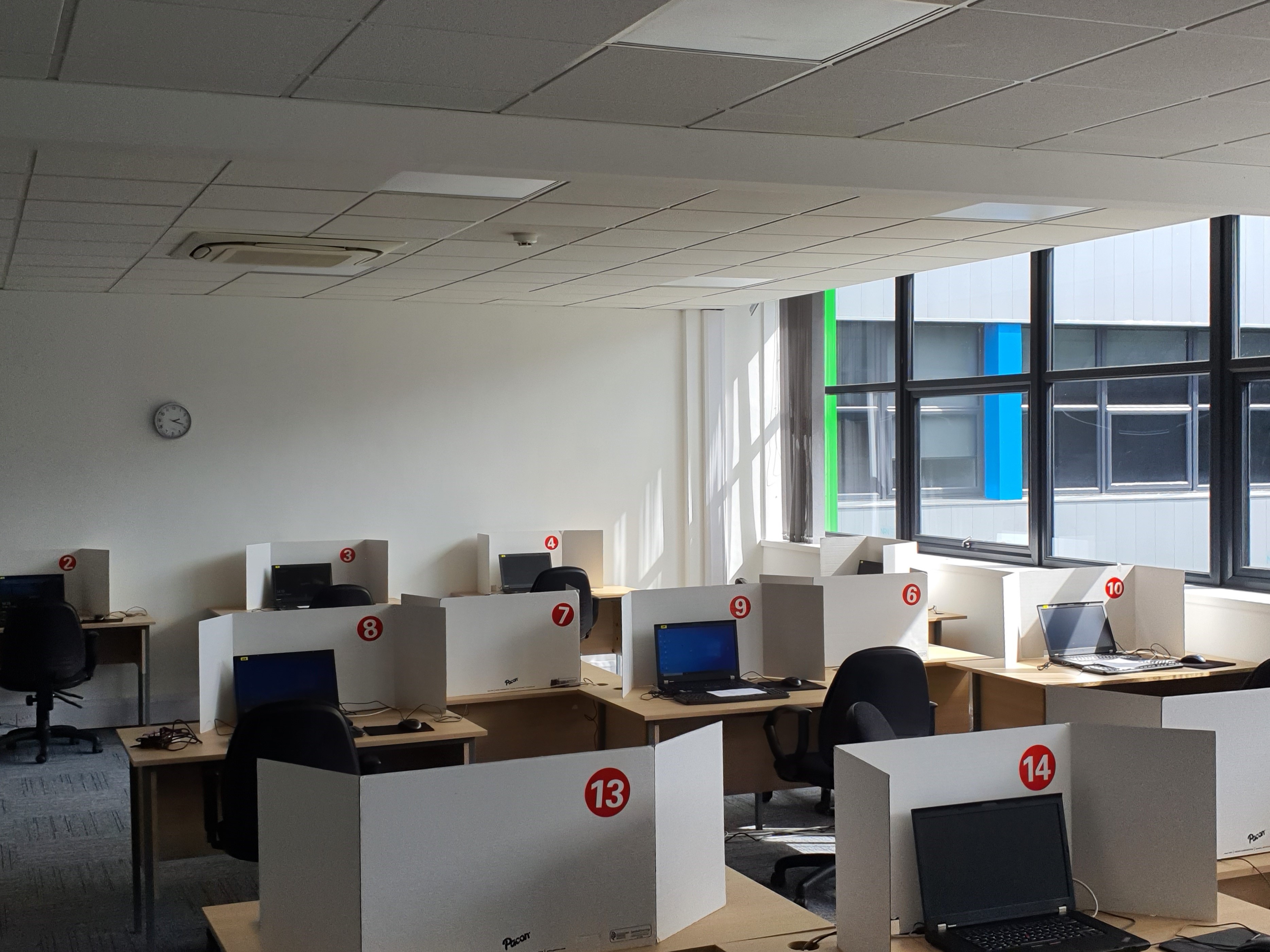 Modern exam training room with computers, ideal for workshops and team events. - Banner