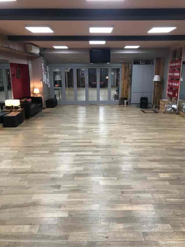 Spacious event venue with polished wooden floors, ideal for workshops and receptions.